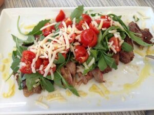 Tagliata di manzo con rucola pomodorini e grana